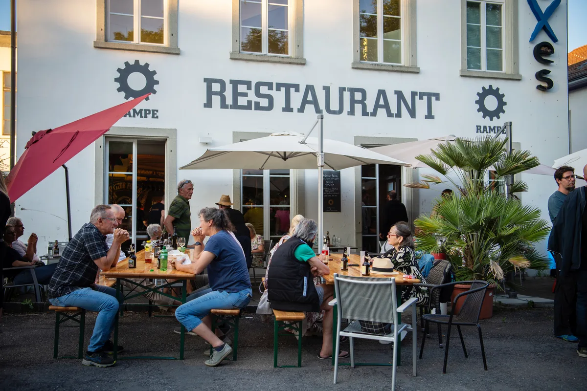 In diesem Sommer fand in der «Rampe» in Bubikon ein grosses Abschlussfest statt. Das Restaurant ging definitiv zu und wird nicht weitergeführt. Eine Gruppe von Menschen sitzt vor einem Lokal mit weisser Fassade.